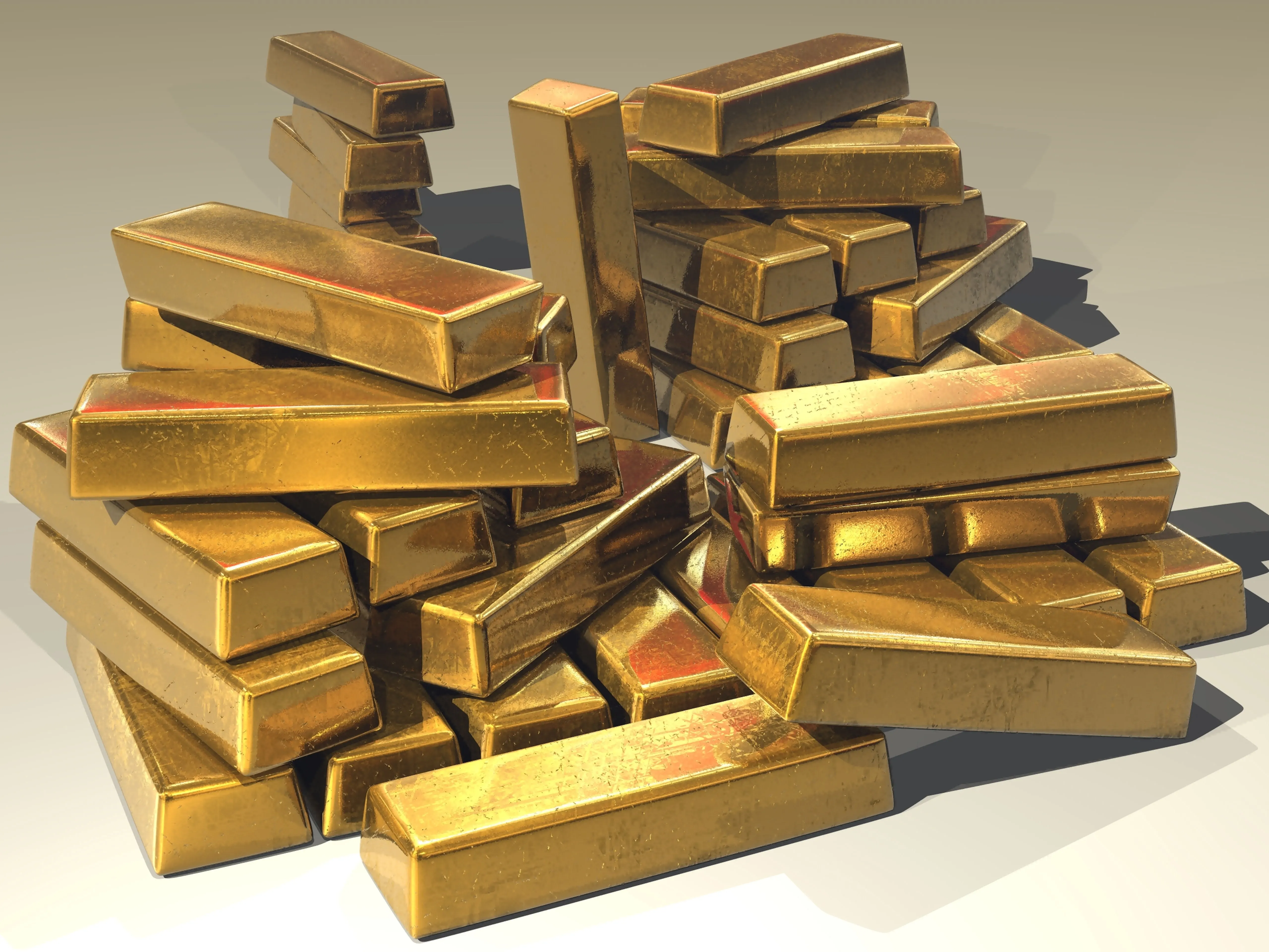 Stapel glänzender Goldbarren auf heller Fläche mit weichen Schatten
